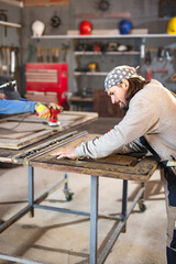 Male carpenter working on old wood in a retro vintage workshop.