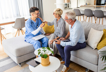 Male nurse talking to seniors patients while being in a home visit.