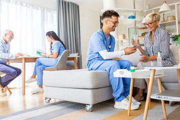 Male nurse talking to senior patient while being in a home visit.