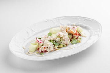 healthy salad with crab meat, radish, cucumbers and peppers isolated on white background