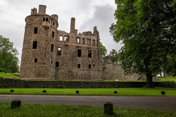 Huntly Castle in Scotland, UK in early evening with a stone wall and tree