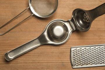manual juicer and grater on wooden board