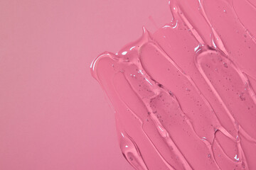 Abstract cosmetic background from transparent gel or antiseptic, hyaluron on pink background