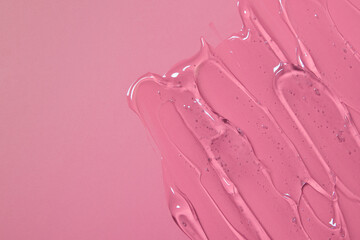 Abstract cosmetic background from transparent gel or antiseptic, hyaluron on pink background