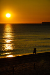 Naklejka na ściany i meble Person silhouette on beach enjoy sunrise