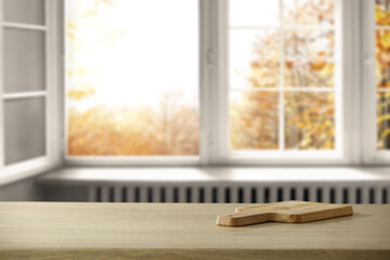 Wooden desk of free space and blurred background of window 