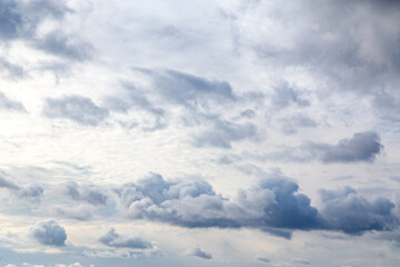Fototapeta premium Stormy sky background with sun shining through the dense set of cumulus clouds scattered by the wind