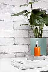 Face serum bottle on table at home bathroom. Minimal styling. Beauty blogging, skin care ad mock up with copy space