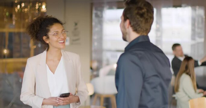 Businesswoman with smartphone greeting colleague with elbow bump