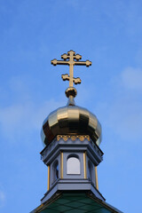 Golden cross on the dome of the church against the blue sky