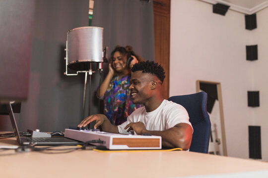 Black friends sharing laptop with recording program on screen