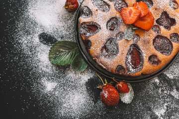 Homemade pie with strawberries and mint on a dark background.
Home cooking, baking. Handmade dessert