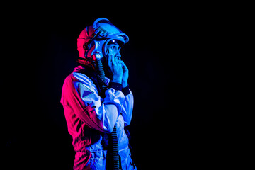 Astronaut in space suit standing in pink and blue neon light