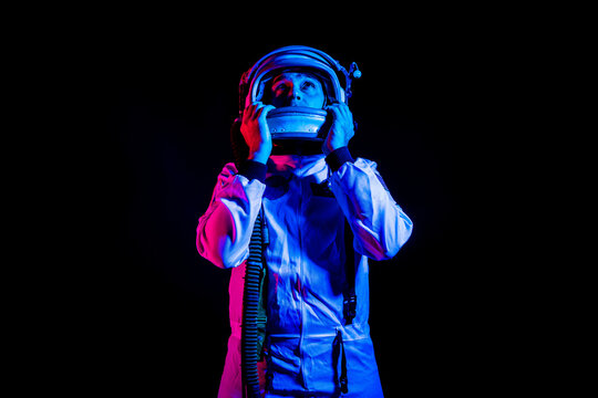 Astronaut in space suit standing in pink and blue neon light