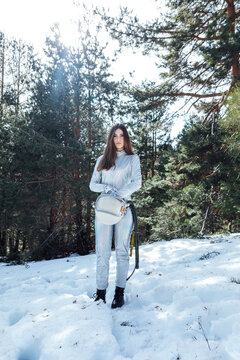 Attractive female astronaut standing in snowy forest