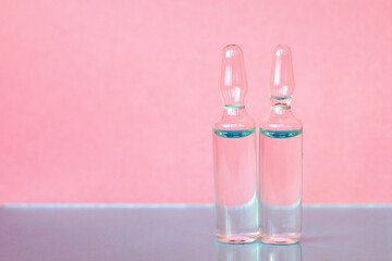 Ampoules for medical and cosmetic products on a pink background. Substance solution for injection