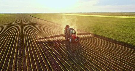 Farmer on tractor spraying soybean field - Powered by Adobe