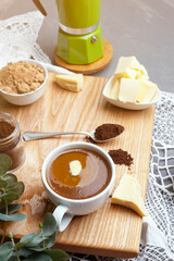 Healthy clean food concept, keto, ketogenic diet, morning breakfast table. Brewed bulletproof coffee with organic coconut oil, ghee and coffee beans. Cozy cafe atmosphere
