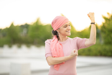 woman fighting cancer, pink scarf happy smile
