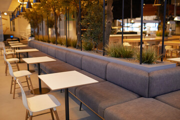 Background image of empty food court interior with single seating tables at shopping mall, copy space