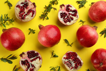 Flat lay composition with ripe pomegranates on yellow background