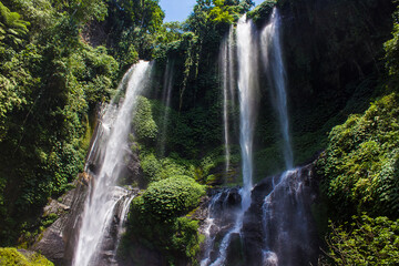 Hidden in jungles beautiful Sekumpul waterfall. The highest waterfall in Bali surrounded by exotic green rainforest. Indonesia. Travel concept.