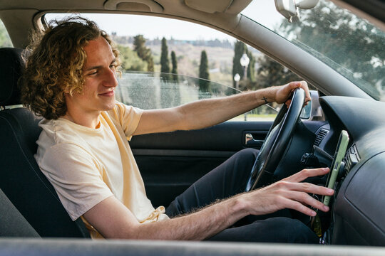 Young man using GPS navigator in car