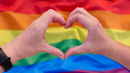 Bisexual, lesbian, woman, person, homosexual holds LGBT flag on the green hills on a sunny day sunset and celebrating a gay parade, Bisexuality Day or National Coming Out Day in pride month