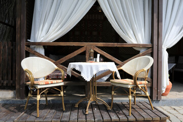Table with two chairs on veranda of cafe