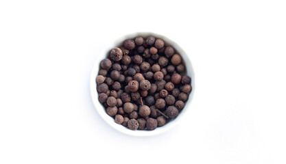 Bowl of allspice isolated on white background top view