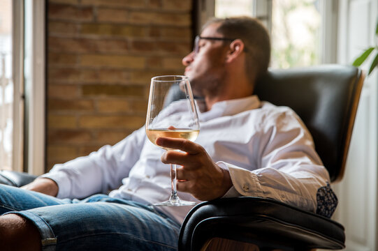 Handsome man relaxing at home with glass of wine