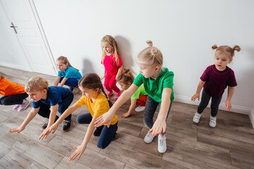 Obraz premium Group of children doing gymnastics in kindergarten or daycare