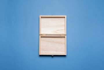 Empty open wooden gift box with a copy space on the blue flat lay background.