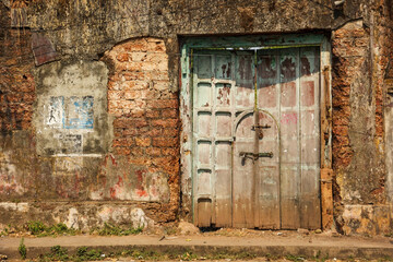An ancient rustic wooden door on an old, laterite brick wall in the heritage town of Fort Kochi.