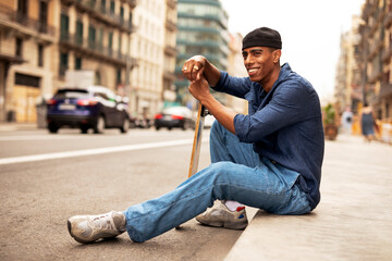 Portrait of happy african-american man with skateboard. Young handsome man with skateboard outdoors