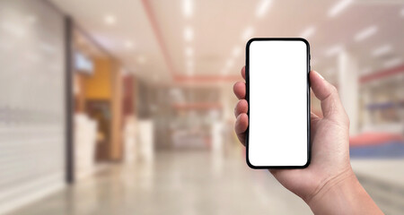 Blank screen of Mobile phone with hand holding phone on Department store soft blurry background. of free space for your copy, Clipping path.