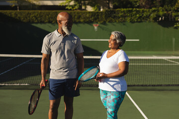 Portrait of smiling senior african american couple with tennis rackets on tennis court © WavebreakMediaMicro