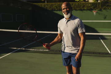 Smiling senior african american man playing tennis on tennis court © WavebreakMediaMicro