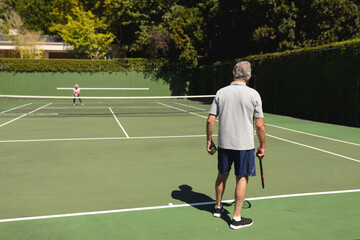 Obraz premium Senior caucasian couple playing tennis together on court