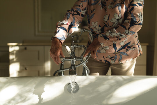 Senior Caucasian Woman Running A Bath In Bathroom