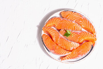 Fresh raw salmon or trout fish fillet steaks. Minimalistic design, modern hard light, dark shadow