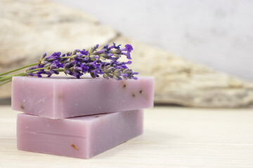 Handmade lavender soap with natural fresh lavender flowers on a gray background. Side view.