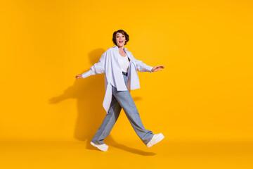 Fototapeta na wymiar Full length body size photo of positive girl going forward cheerful careless isolated on vibrant yellow color background