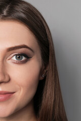 Naklejka premium Beautiful woman with black eyeliner on grey background, closeup