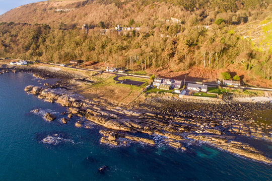 Garron Point, Northern Ireland, UK. A geological formation and parking at Antrim Coast Road, a.k.a. Causeway Coastal Route. One of the most scenic coastal roads in Europe. Aerial view in sunrise light