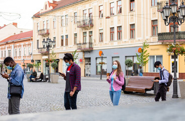 People in masks stand queue keeping social distance