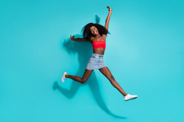 Fototapeta na wymiar Full size photo of crazy happy afro american young woman jump up smile isolated on pastel blue color background