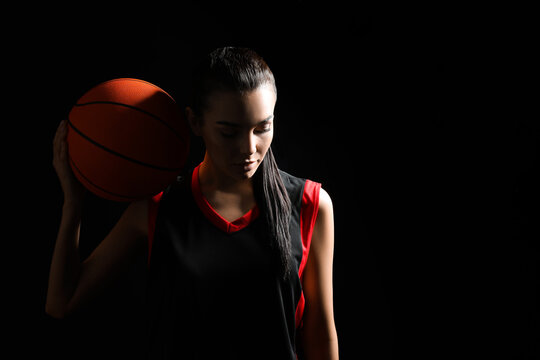 Basketball player with ball on black background. Space for text