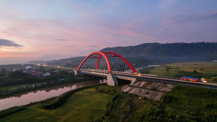 Aerial view of the Kalikuto Bridge, an Iconic Red Bridge at Trans Java Toll Road, Batang when sunrise. Central Java, Indonesia, July 1, 2021
