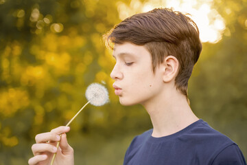  portrait a boy blowing dandelion. Medical, healthy concept.